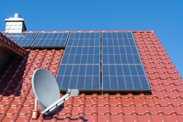 solar panels on a red tiled roof with satellite dish