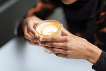 Close-up of female hands holding coffee