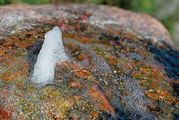 Kleine Wasserfont&auml;ne auf einem bunten Stein