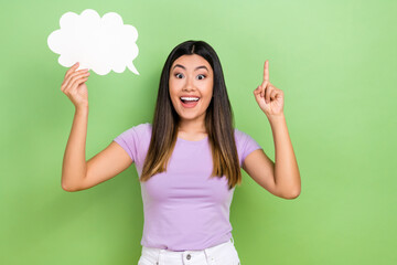 Photo of attractive young japanese woman idea finger pointing up hold paper bubble cloud idea eureka isolated on green color background