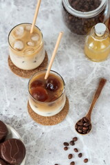 Iced coffee and milk in glasses with straws on the table. Vertical arrangement