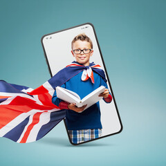 Cute superhero boy reading a book  in a smartphone videocall and smiling, online  education concept