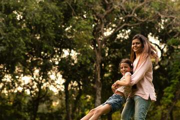 Obraz premium Happy Young Indian woman and daughter in the park