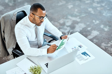 Financial analyst, focus and black businessman planning in an office or reading report and employee...