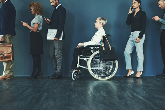 Waiting, interview line and woman inclusion in wheelchair for business recruitment in office. Diversity, technology and employee people with disability in waiting room queue for hiring inn workplace