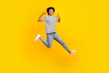 Fototapeta na wymiar Full length body photo of crazy brutal punk music lover guy jumping showing metal sign hipster isolated on yellow color background