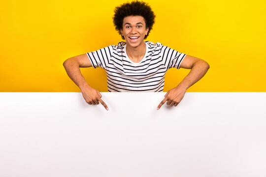 Photo of young man pointing fingers empty space huge billboard placard cheap food italian pizza isolated on yellow color background