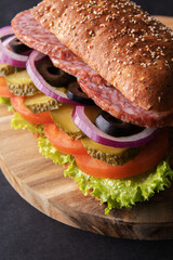 photo sausage sandwich with salted cucumber, tomato, lettuce, olives and onions