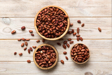 Fresh healthy peanuts in bowl on colored table background. Top view Healthy eating bertholletia concept. Super foods