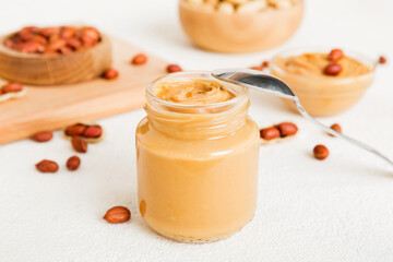 Bowl of peanut butter and peanuts on table background. top view with copy space. Creamy peanut pasta in small bowl