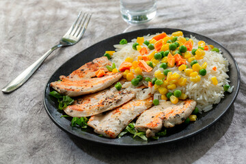 Fototapeta na wymiar Healthy sports meal, grilled chicken breast with sauteed vegetables and rice on gray background 2
