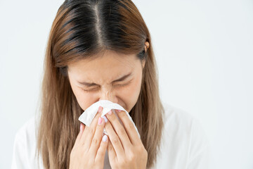 Pollen Allergies, asian young woman sneezing in a handkerchief or blowing in a wipe, allergic to wild spring flowers or blossoms during spring. allergic reaction, respiratory system problems