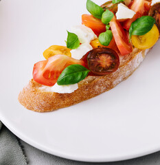 Traditional italian bruschetta with cherry tomatoes and basil leaves