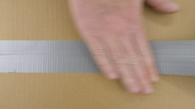Carton box with chromakey inside. Packing and sealing cardboard box with duct tape.