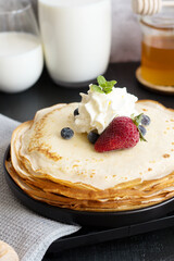 
Fresh pancakes with berries. Breakfast. On a dark background
