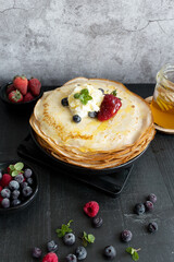 
Fresh pancakes with berries. Breakfast. On a dark background