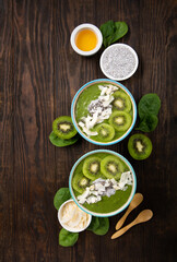 Green Smoothie Bowl with Spinach, Banana, Chia Seeds on Brown Background
