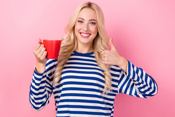 Photo of young positive business lady wear striped pullover thumb up like recommend espresso macchiato cup isolated on pink color background