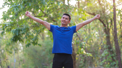 Fototapeta premium Pleasant athletic man in sportswear with arms up celebrating success and goals after working out.