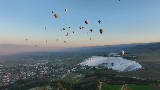 Hot air balloons and Natural travertine pools at sunrise in Pamukkale, 
