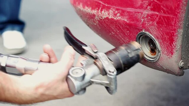 Hand Using LPG Filling Nozzle to Refuel Car at Autogas Filling Station.