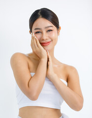 Isolated cutout studio shot millennial Asian beautiful pretty sexy female model in tube cropped top shirt standing smiling holding hand on face showing presenting painting nails on white background