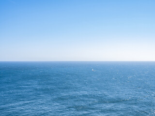 Obraz premium Ozean mit blauem Himmel und Segelboot