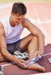 Injury, outdoor and man with water bottle on feet for exercise, running or workout pain at a sports...