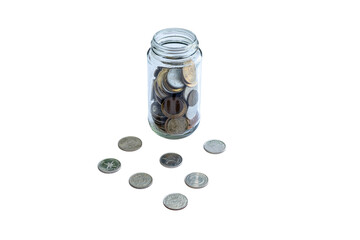 A jar full of coins with some spread outside