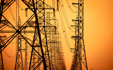 High voltage electric transmission tower. High voltage power lines on electric pylon against a sunset sky. Electrical infrastructure. Energy crisis. Electric power distribution. Energy distribution.