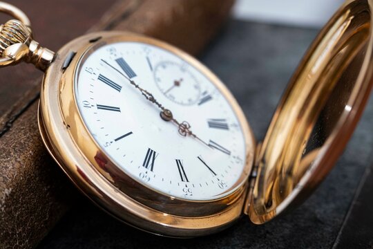 vintage gold pocket watch longines isolated on white background, pocket watch on books background