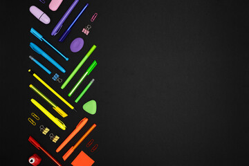 Creative layout made of neon colorful stationery set on black background. Place for your text