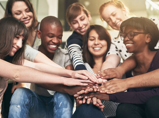 Obraz premium Goal, motivation and friends with their hands in a huddle together for education, support or success. Teamwork, smile and trust with a happy group of students bonding at college or university