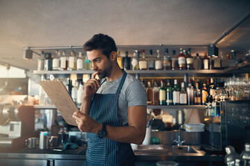 Man in restaurant, checklist on clipboard and inventory check, small business and entrepreneur in hospitality industry. Male owner reading list, think and cafe franchise with admin and stock taking