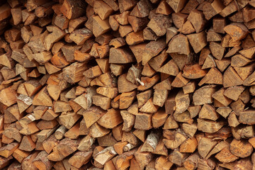 Split birch logs for the fireplace are stacked on top of each other. Wood for a picnic. Betulaceae. Firewood