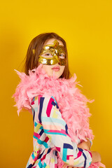 A joyful teenager girl wearing a colorful Brazil carnival mask