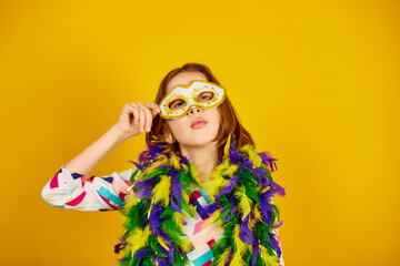 A joyful teenager girl wearing a colorful Brazil carnival mask