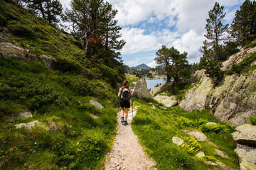 Young hiker girl summit to Ratera Peak in Aiguestortes and Sant Maurici National Park, Spain
