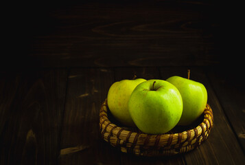 Green organic healthy apples in bowl on wooden board. Healthy food