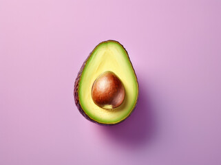 Avocado cut in half on a pastel pink background, flat lay with copy space