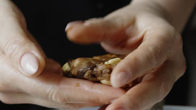 A woman makes biscuits out of dough. Cookies with peanuts and chocolate chips. Close-up. Slow motion.