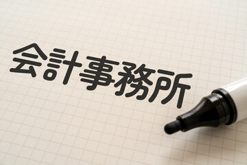 会計事務所と書かれたノートとマーカー