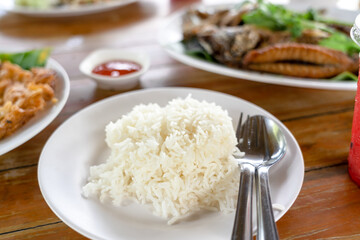 Cooked white rice and side dish on wooden table in restaurant. Thai Asian cuisine food  style.