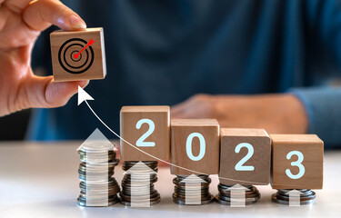 Human hand holding wood cube target and coins arrow business financial investment graph, business growth, money, 2023, chart, target, investment, funds, saving money, banking, marketing, profit