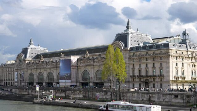 Paris, France - 3 May 2023. Famous art museum called Musee d'Orsay by Seine river in Paris on sunny day. Giant clock and exterior facade of Orsay museum. Landmarks of France. Shooting in slow motion