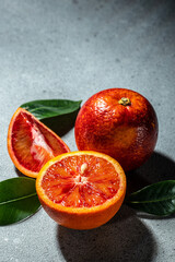 Bloody Sicilian oranges on a grey background, whole and cut sliced, halved with leaves, pattern....