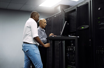 Server room, people or technician coding on computer together for a cybersecurity glitch with teamwork. IT support code, collaboration or engineers fixing laptop network for information technology