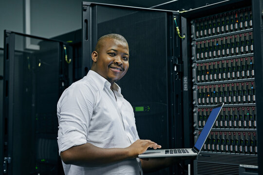 Server room, black man or portrait of technician with laptop for online cyber security glitch or software. IT support, happy or friendly African engineer fixing network for information technology