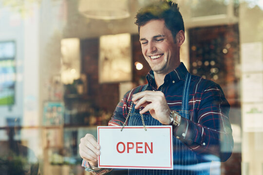 Open sign, cafe and man with business, startup and poster with service, board and franchise window. Male person, happy employee and entrepreneur with a waiter, new and opening store with hospitality
