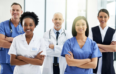 Confidence, crossed arms and portrait of team of doctors standing in the hallway with collaboration. Happy, diversity and group of healthcare workers in the corridor of a medical clinic or hospital.